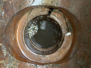 A cracked and leaking gully pot can cause property damp issues in Slough